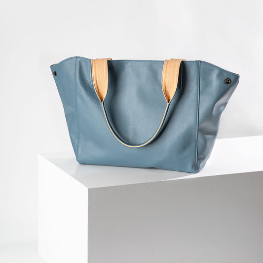Blue tote bag with wooden handles on a white background