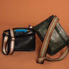 Two black handbags with striped handles on a brown background